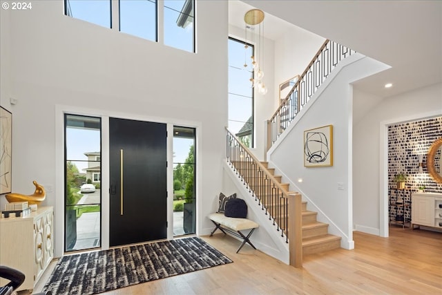 entryway with a towering ceiling and light hardwood / wood-style floors