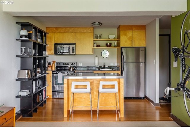 kitchen with a center island, stainless steel appliances, dark hardwood / wood-style floors, and sink