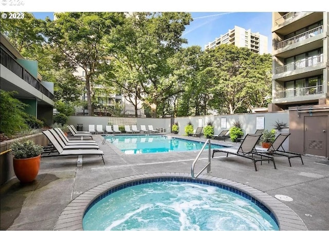 view of swimming pool with a hot tub