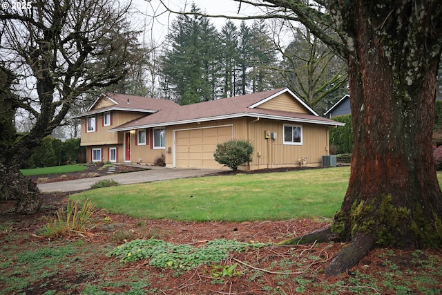 view of front of home featuring a front lawn, central AC unit, and a garage