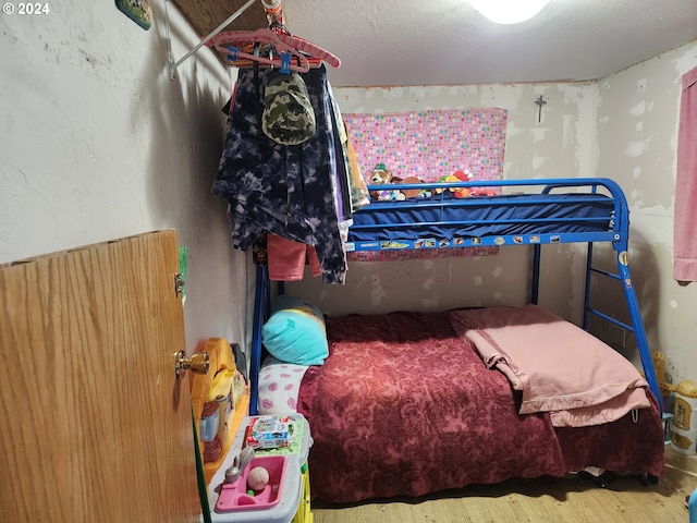 bedroom with wood-type flooring and wood walls