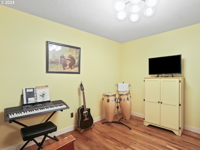 misc room with a textured ceiling and light wood-type flooring