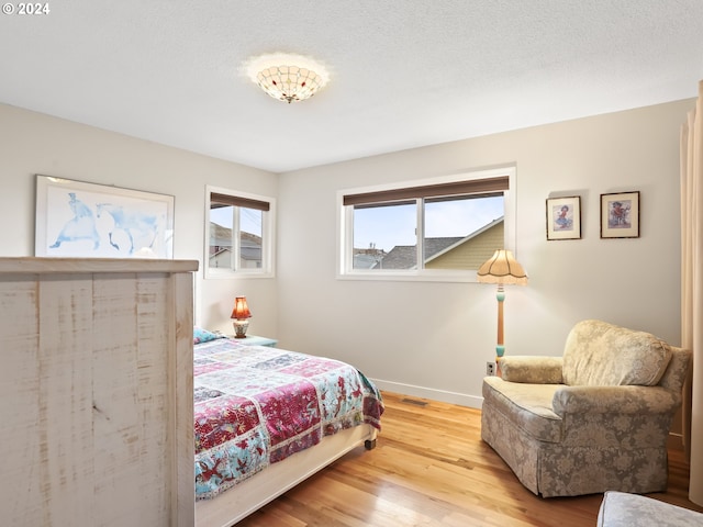 bedroom featuring a textured ceiling and light wood-type flooring