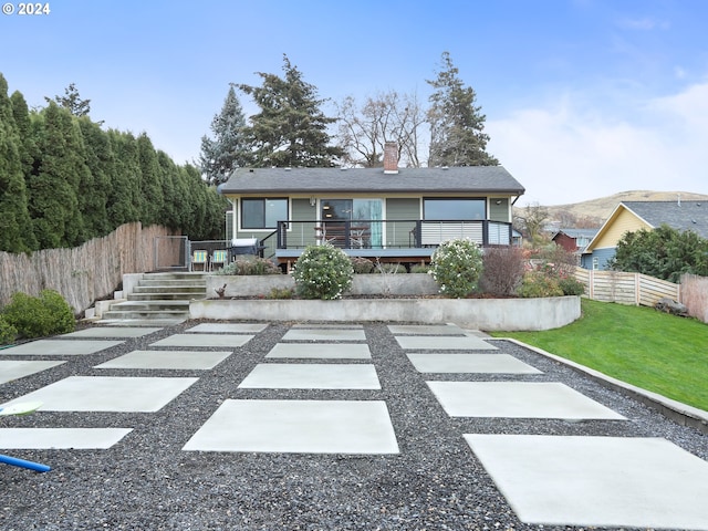 view of front of property featuring a deck and a front lawn