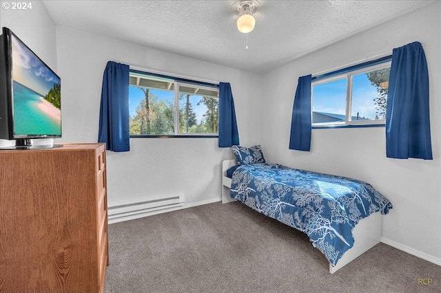 bedroom with a baseboard radiator, a textured ceiling, carpet flooring, and multiple windows