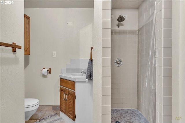 bathroom featuring vanity, tile patterned floors, toilet, and curtained shower