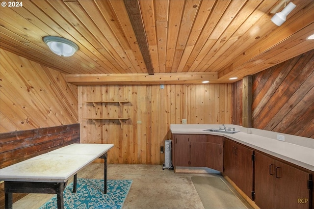 interior space featuring wooden ceiling, sink, and wooden walls