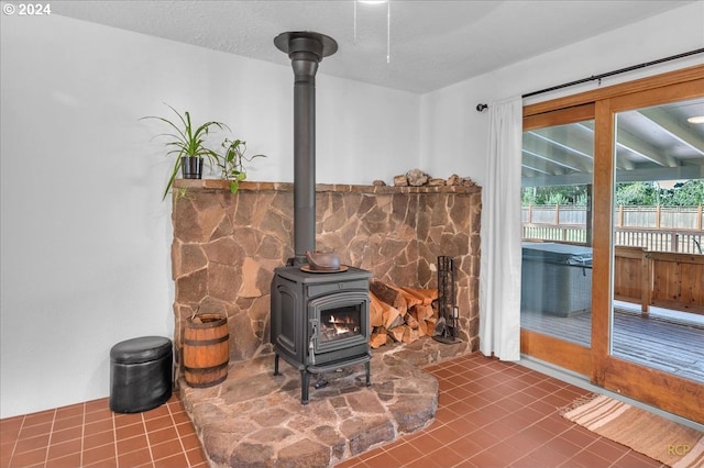 details with a wood stove, tile patterned floors, and a textured ceiling