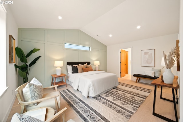 bedroom featuring multiple windows, hardwood / wood-style floors, and lofted ceiling