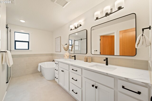 bathroom featuring tile walls, a bathtub, and vanity