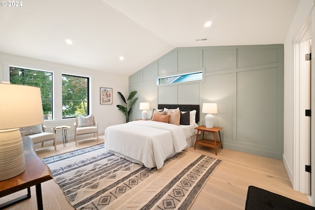 bedroom featuring lofted ceiling and light wood-type flooring