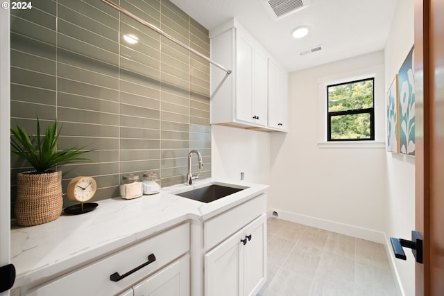 clothes washing area featuring sink, cabinets, and washer hookup