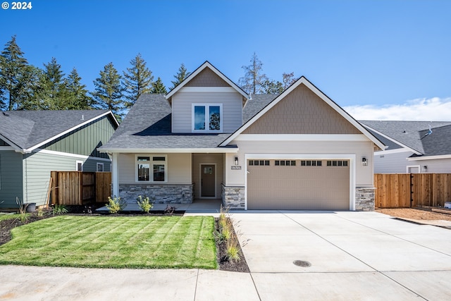 craftsman house featuring a front yard and a garage