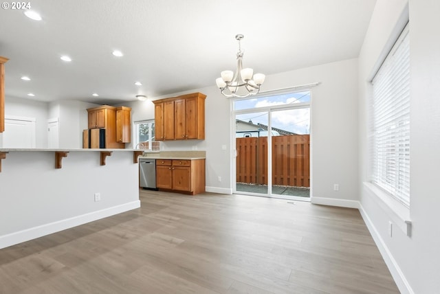 kitchen featuring dishwasher, a chandelier, plenty of natural light, and light hardwood / wood-style floors