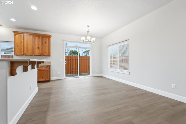 unfurnished dining area featuring dark wood-type flooring and a chandelier