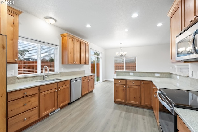 kitchen with pendant lighting, plenty of natural light, sink, and stainless steel appliances