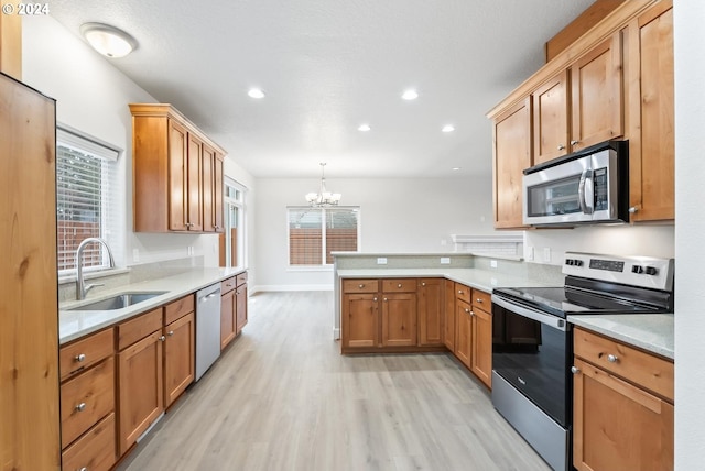 kitchen featuring hanging light fixtures, stainless steel appliances, a notable chandelier, kitchen peninsula, and light hardwood / wood-style floors