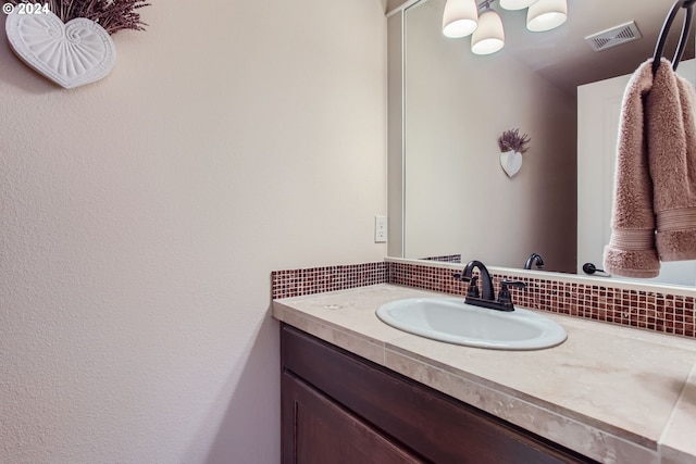 bathroom featuring vanity and tasteful backsplash