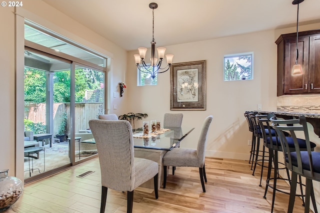 dining area with a wealth of natural light, a chandelier, and light wood-type flooring