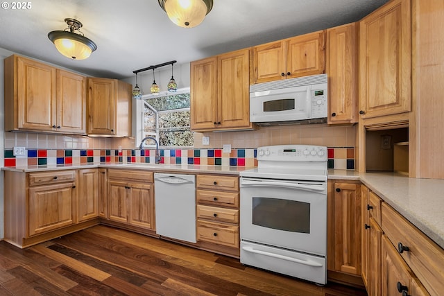 kitchen with a sink, white appliances, backsplash, and dark wood-style flooring