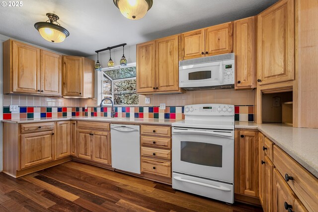 kitchen with backsplash, dark wood-type flooring, light countertops, white appliances, and a sink