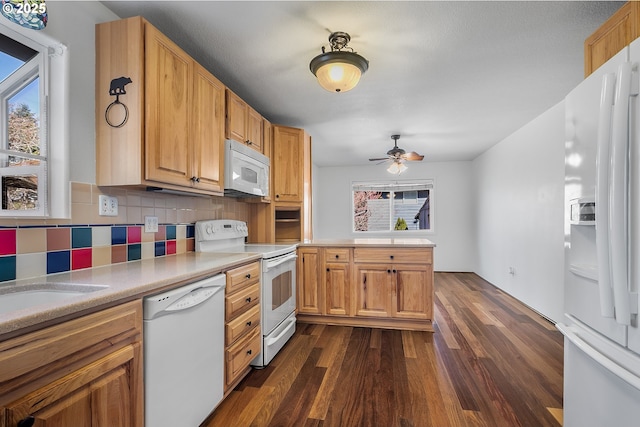 kitchen with white appliances, dark wood finished floors, a peninsula, light countertops, and tasteful backsplash