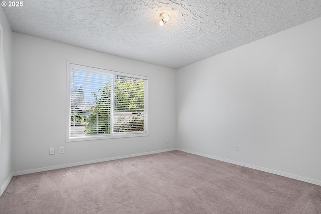 carpeted empty room with baseboards and a textured ceiling