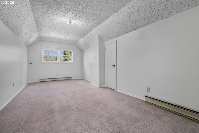 additional living space with carpet, vaulted ceiling, a textured ceiling, a baseboard heating unit, and baseboard heating