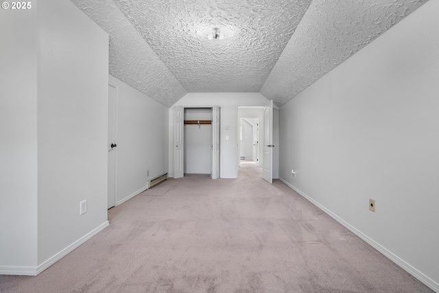 bonus room with light carpet, a textured ceiling, baseboards, baseboard heating, and vaulted ceiling