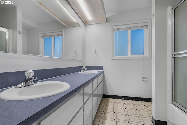 full bathroom featuring tile patterned floors, double vanity, baseboards, and a sink