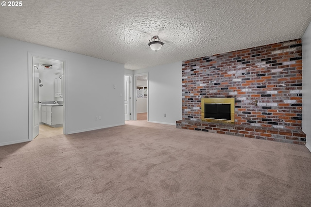 unfurnished living room featuring baseboards, a textured ceiling, a brick fireplace, and carpet flooring