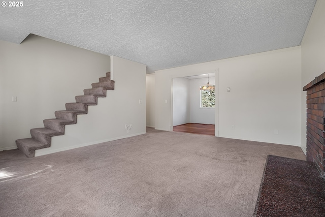 unfurnished living room featuring stairway, a textured ceiling, and carpet flooring