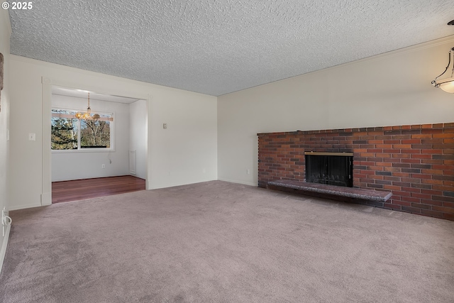 unfurnished living room featuring a brick fireplace, carpet floors, and a textured ceiling