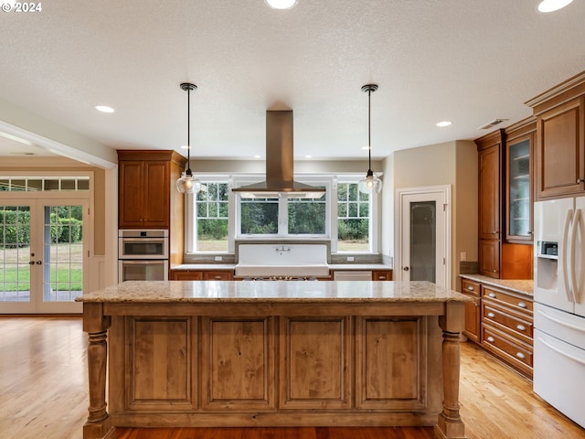 kitchen featuring light hardwood / wood-style floors, plenty of natural light, island exhaust hood, and white refrigerator with ice dispenser