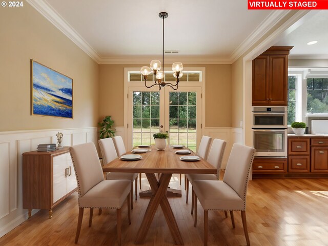 dining space with light hardwood / wood-style floors, a notable chandelier, and ornamental molding