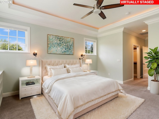 carpeted bedroom featuring a tray ceiling, ceiling fan, and crown molding