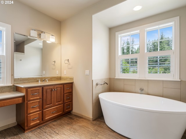 bathroom featuring a tub, tile walls, and vanity