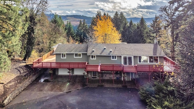 rear view of property with a deck with mountain view