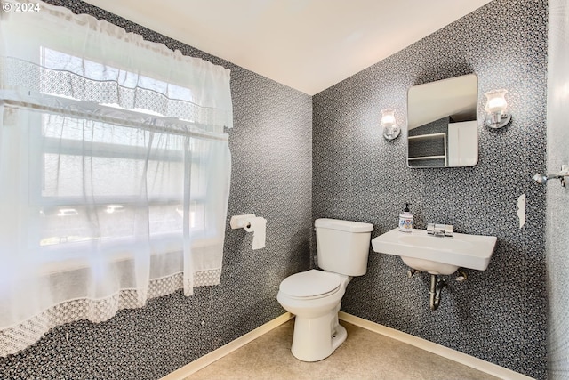 bathroom with lofted ceiling, sink, and toilet