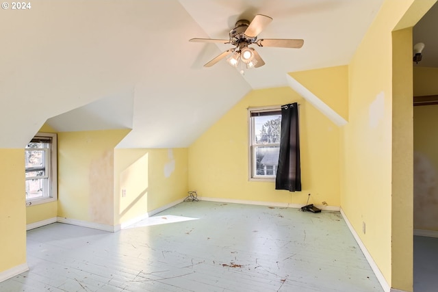 additional living space featuring lofted ceiling, a healthy amount of sunlight, light wood-type flooring, and ceiling fan