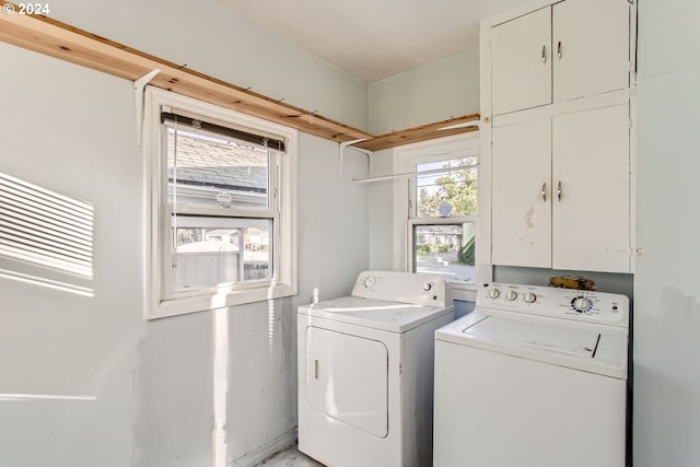 laundry room with cabinets, plenty of natural light, and washing machine and clothes dryer