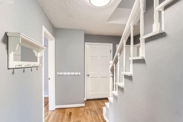 entrance foyer with light hardwood / wood-style flooring and a textured ceiling