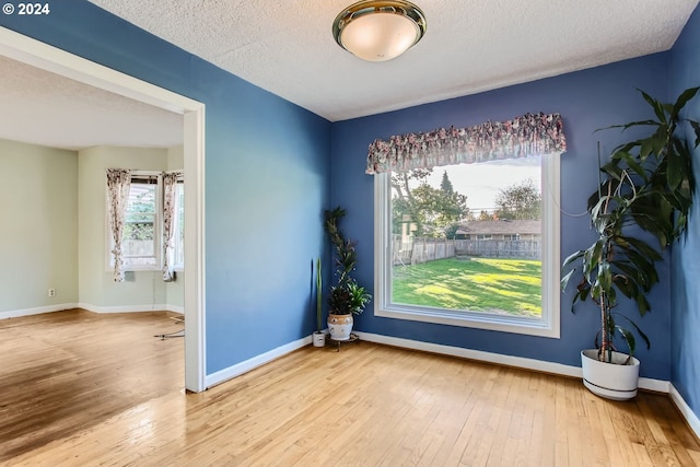 spare room with a textured ceiling and hardwood / wood-style floors