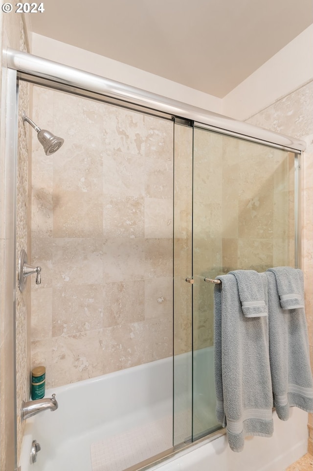 bathroom featuring combined bath / shower with glass door