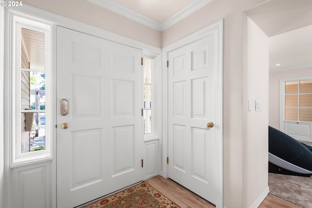 foyer featuring ornamental molding and light hardwood / wood-style flooring