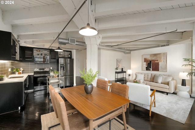 dining space featuring beam ceiling, dark hardwood / wood-style floors, and sink