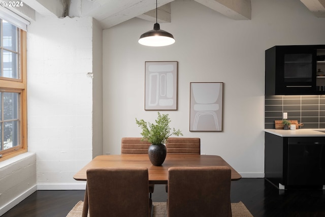 dining space featuring beamed ceiling, plenty of natural light, and dark hardwood / wood-style flooring