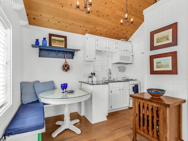 kitchen featuring white cabinetry, breakfast area, a wealth of natural light, and white appliances