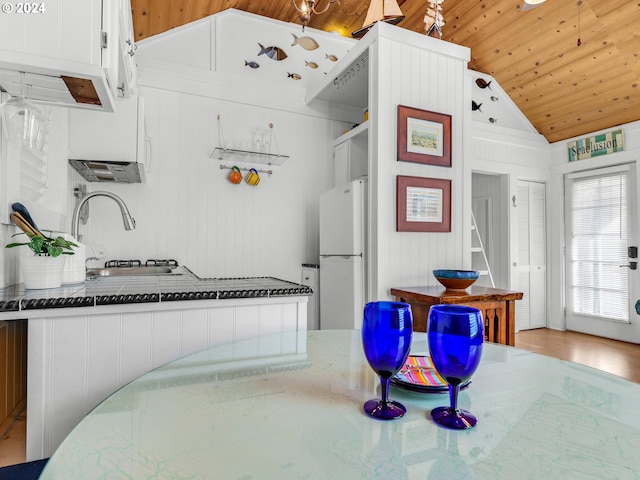 kitchen featuring white fridge, wooden ceiling, light wood-type flooring, and vaulted ceiling