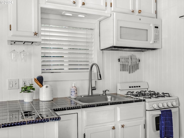 kitchen featuring white appliances, sink, and white cabinets